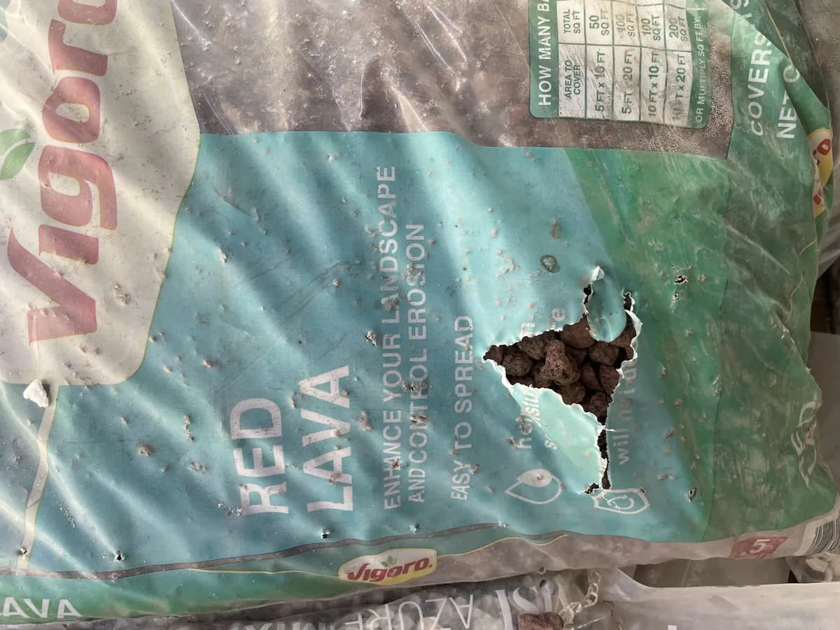 Bag of red lava rock punctured from the inside