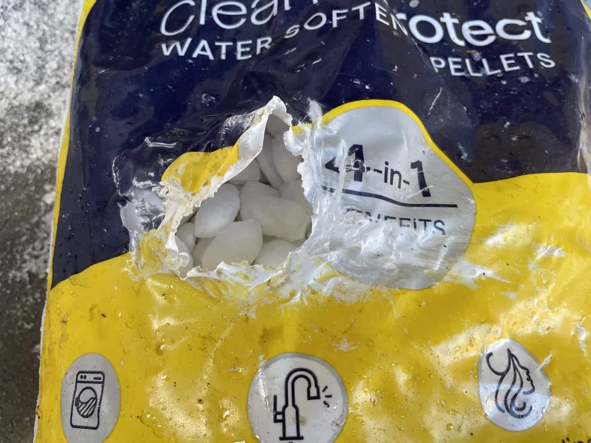 Water softener pellet bag with a hole punched through it