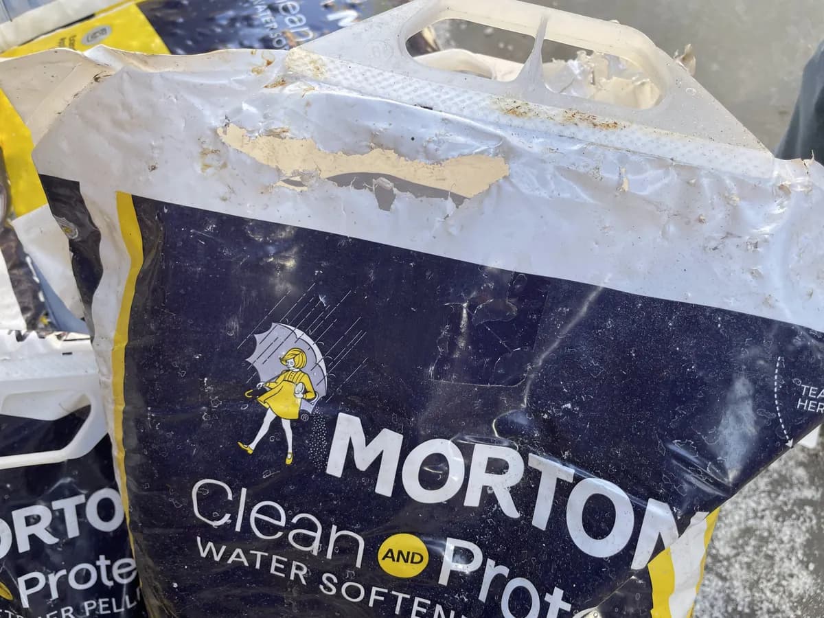 Bag of water softener pellets torn open on a pallet